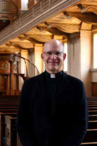 Portrait of Reverend Dr Robert Tobin inside the Chapel of St Peter & St Paul