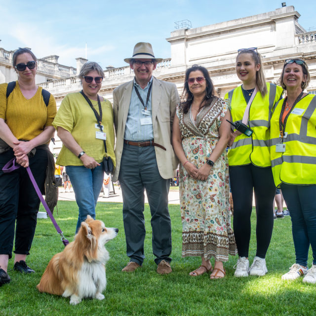 A group of people standing in front of a dog