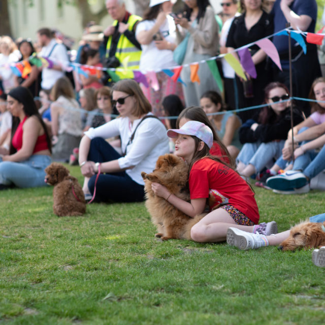 a group of people sitting on grass with a dog