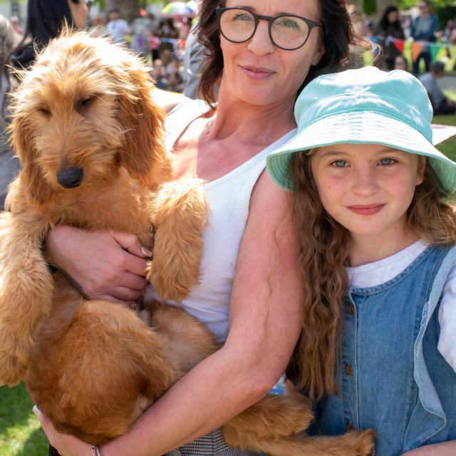 a person and a child holding a dog