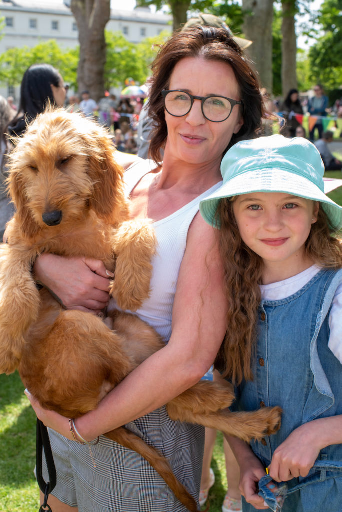 a person and a child holding a dog